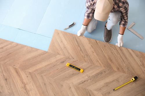 https://crsmove.com/wp-content/uploads/2023/03/Worker-installing-laminated-wooden-floor.jpg