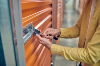 Worker padlocking the door of the storage unit