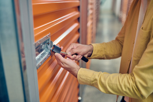 Worker-padlocking-the-door-of-the-storage-unit.jpg