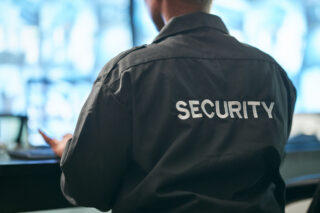 Office safety, back and man or security for a business or building for service. Law patrol, working and a worker at a professional job as a bodyguard or agent for protection at a workplace or agency